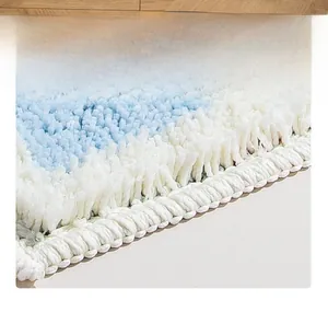 Close-up of thick blue and white gradient plush bath mat with reinforced edge stitching