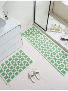 Close-up of green checkered bath mat set with pink dots made of soft flocked fiber fabric