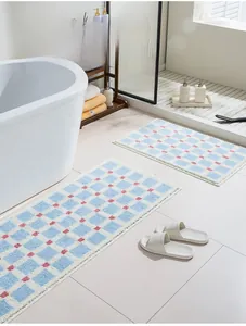Blue and white checkered bath mat set with pink dots in a cozy bathroom setting