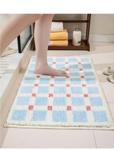Close-up of plush blue and white checkered absorbent bath mat with soft microfiber texture