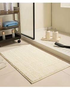 Close-up of a thick cream bathroom mat with elegant horizontal striped texture