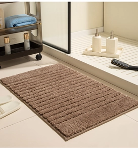 Close-up of brown absorbent bath mat with non-slip texture and striped fiber surface