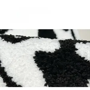 Close-up of thick cat-themed bath mat featuring soft black and white spotted plush texture