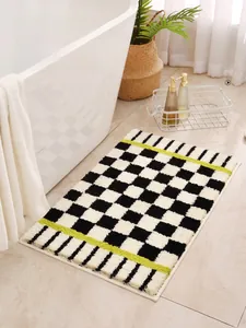 Close-up of checkerboard bathroom mat featuring soft plush fibers and green accent lines