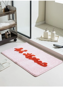 Dettaglio del tappeto da bagno rosa con trama a pelo alto e scritte 3D Hi Kisses