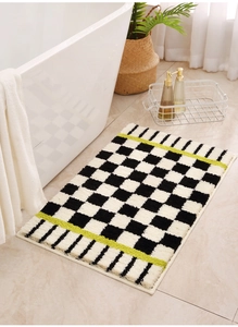 Close-up of checkerboard bath mat with neon green stripe and plush flocking texture
