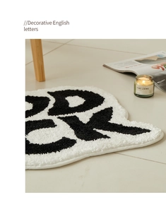 Close-up of plush absorbent bathroom mat with bold decorative English letters in high texture