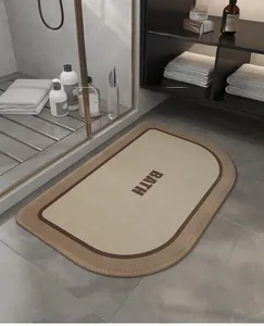 Detailed view of beige absorbent bath mat with BATH text on gray bathroom floor