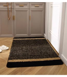 Close-up of thick non-slip entry mat with golden textures on herringbone wood floor