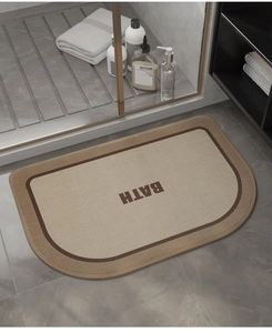 Detail of a semi-oval woven bath mat with a cream and brown texture and BATH text