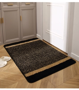 Close-up of thickened black and gold striped entryway mat with plush non-slip texture
