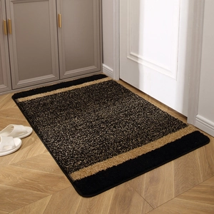 Thick non-slip entrance rug in black and beige contrast pattern on wooden floor