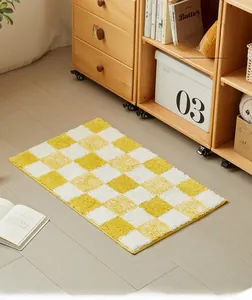 Detail of yellow checkerboard bath mat with thick flocked texture and anti-slip backing