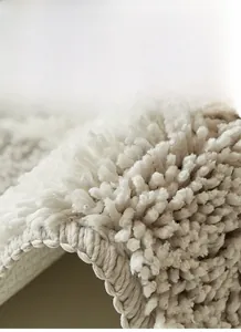 Detailed close-up of thick high-density plush pile and durable stitching on bathroom mat