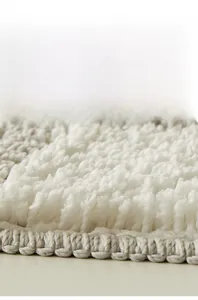 Macro shot of thick high-density checkerboard bath mat showing soft fibers and durable edges