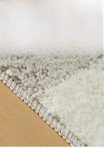 Close-up of thick grey and white striped bathroom mat with durable woven edges