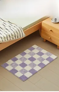 Detail view of purple and white checkered bath mat with soft plush texture in a bedroom