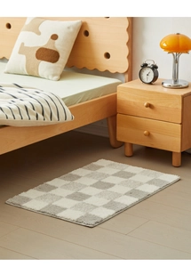 Macro detail of soft microfiber checkered bath mat on light wood flooring in a cozy bedroom