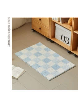 Detail of blue and white checkered bathroom rug with soft plush texture on wood floor