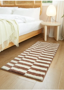 Close-up of thick striped bedroom runner rug with plush texture and neat stitched edges