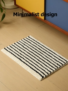 Detalle de alfombra de baño minimalista a rayas blancas y negras sobre madera