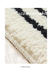 Detalle de textura de felpa suave y costuras densas en la alfombra de rayas blancas y negras