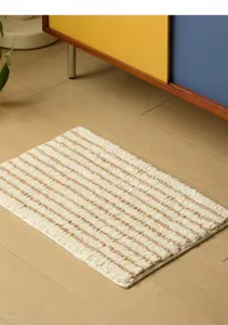 Detalle de alfombra de baño suave con textura de rayas y base antideslizante