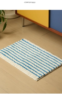 Primer plano detallado de la alfombra de baño de felpa a rayas azules y blancas con bordes