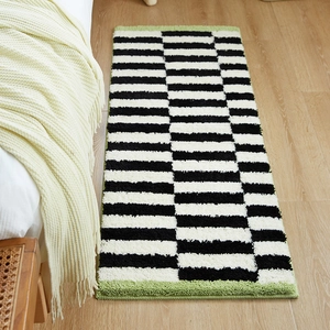 Thick black and white striped runner rug with green tufted edges for bedroom or hallway