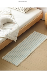 Nahaufnahme des blau-weiß gestreiften Plüschteppichs mit Saumkanten im Schlafzimmer