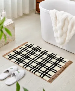 Detail of Bauhaus style non-slip bathroom mat with plaid pattern on wood floor