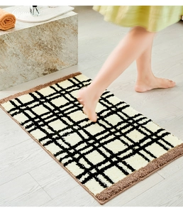 Detailopname van dik absorberend badkamerkleed met ruitpatroon op houten vloer