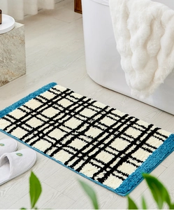 Detail van de dikke absorberende pluche badmat met zwart en wit rasterpatroon design