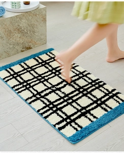 Detail van Bauhaus getufte badmat met zachte pluche textuur en blauwe randafwerking