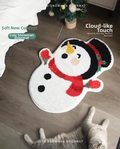 Detail of soft snowman Christmas mat on wood floor with cute cat and festive tree