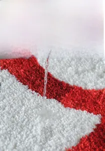 Close-up of thick plush snowman mat showing high water absorption and soft red texture