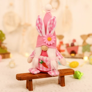 Easter gnome plush doll with rabbit ears and carrot embroidery on a wooden bench