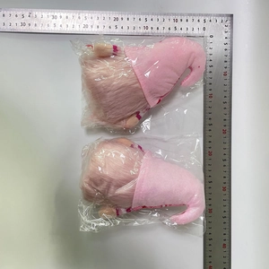 Quality check of pink striped gnome dolls with plush fabric in plastic packaging