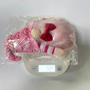 Weight measurement of a pink Valentine gnome plush with heart hat on electronic scale