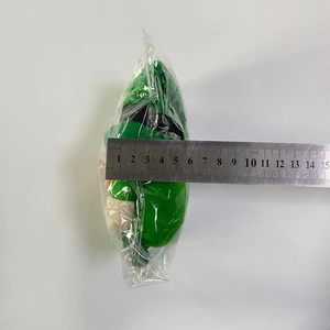 Detail showing the width measurement of the green gnome plush toy with a metal ruler