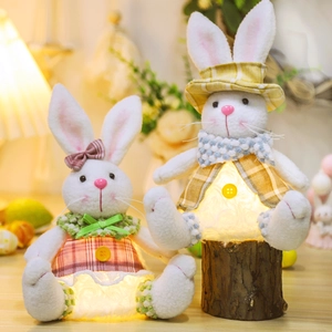Close-up of glowing Easter bunny plush decorations with warm LED lights and plaid outfits