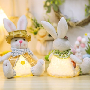 Detail of two plush Easter bunnies with built-in LED warm lights and festive fabric outfits