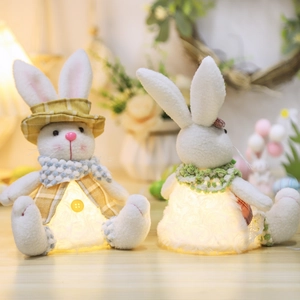 Pair of glowing plush Easter bunnies with plaid accessories on warm home background
