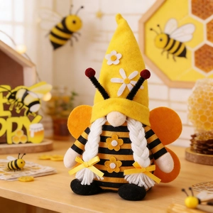 Detail of bee gnome plush with striped body, yellow hat, and wings for spring decor