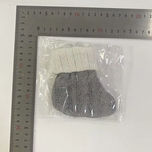 Dettaglio della mini calza di Natale grigia in maglia a trecce con bordo in crema
