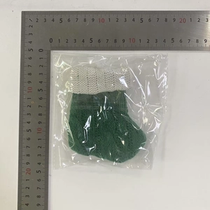Mini calza natalizia in maglia verde con righello che mostra l'altezza di 11cm