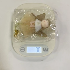 Weight measurement of plush angel ornament in packaging showing 10g on a digital scale