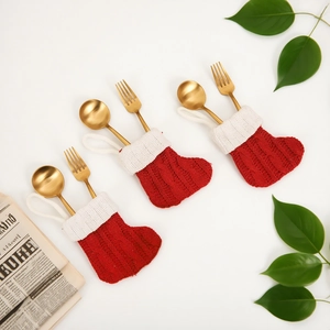 Tre calze natalizie in maglia a righe rosse portaposate con cucchiai e forchette d'oro