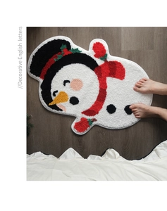 Close-up of tufted snowman shaped Christmas mat with non-slip backing on wood floor