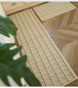 Waffle texture cream kitchen mat set with brown accents on wood floor detail